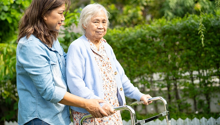 woman helping an elderly woman with a walker