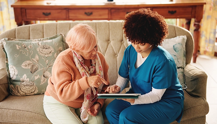 woman helping another woman on a sofa